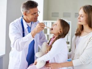 doctor-examining-little-girl-with-her-mother-medical-office_1098-365